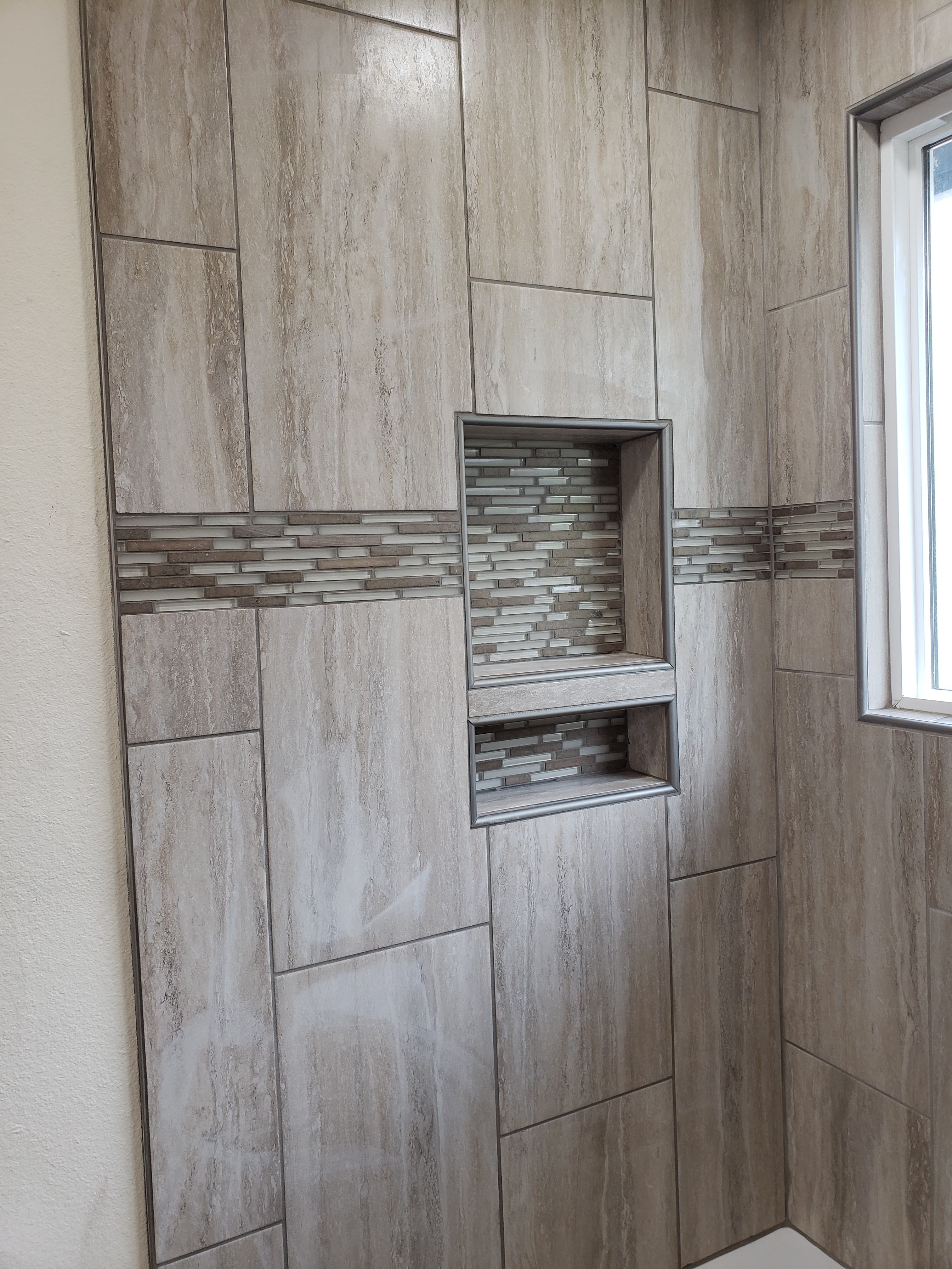 Professional bathroom remodel project featuring large format tile floor decorative inlay
