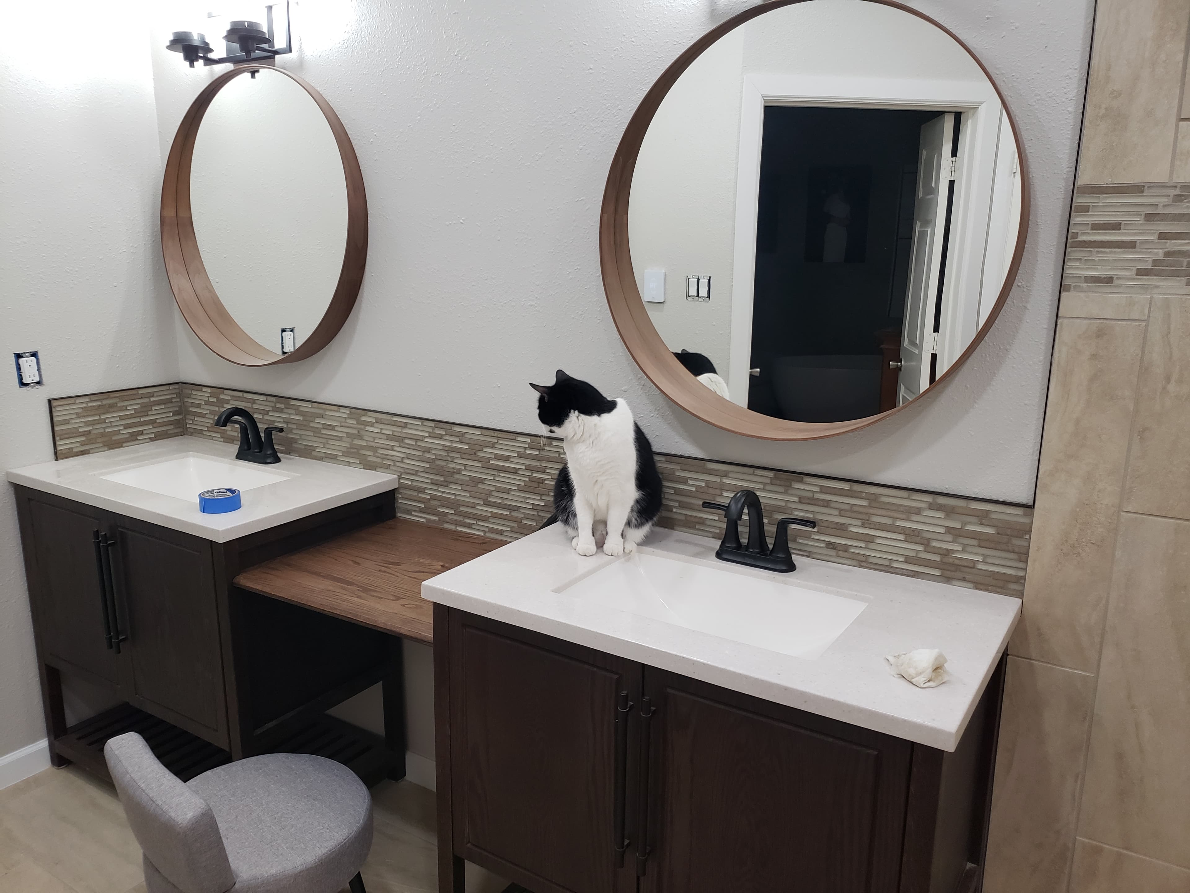 Professional bathroom remodel project featuring master bathroom dual vanities bronze mirrors tile backsplash