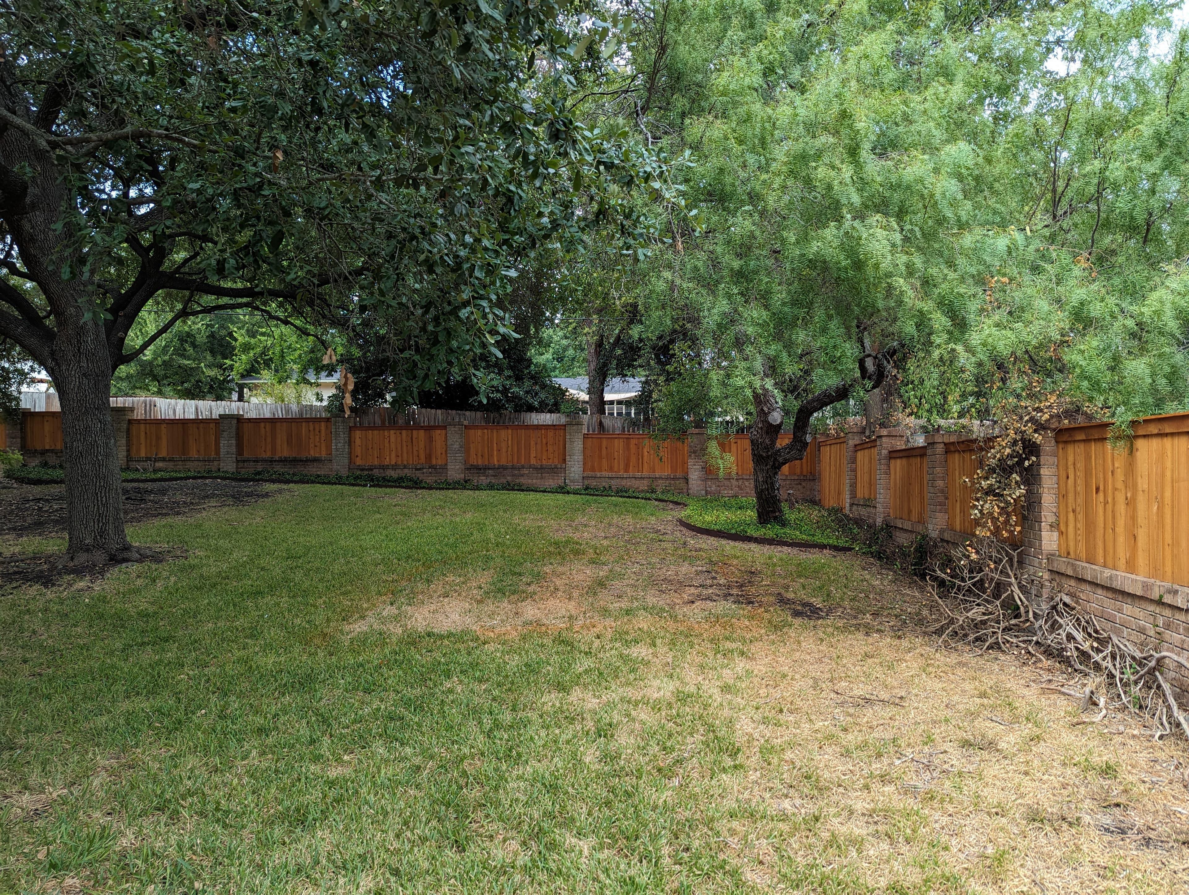 Professional fencing project featuring cedar fence stone columns residential gate
