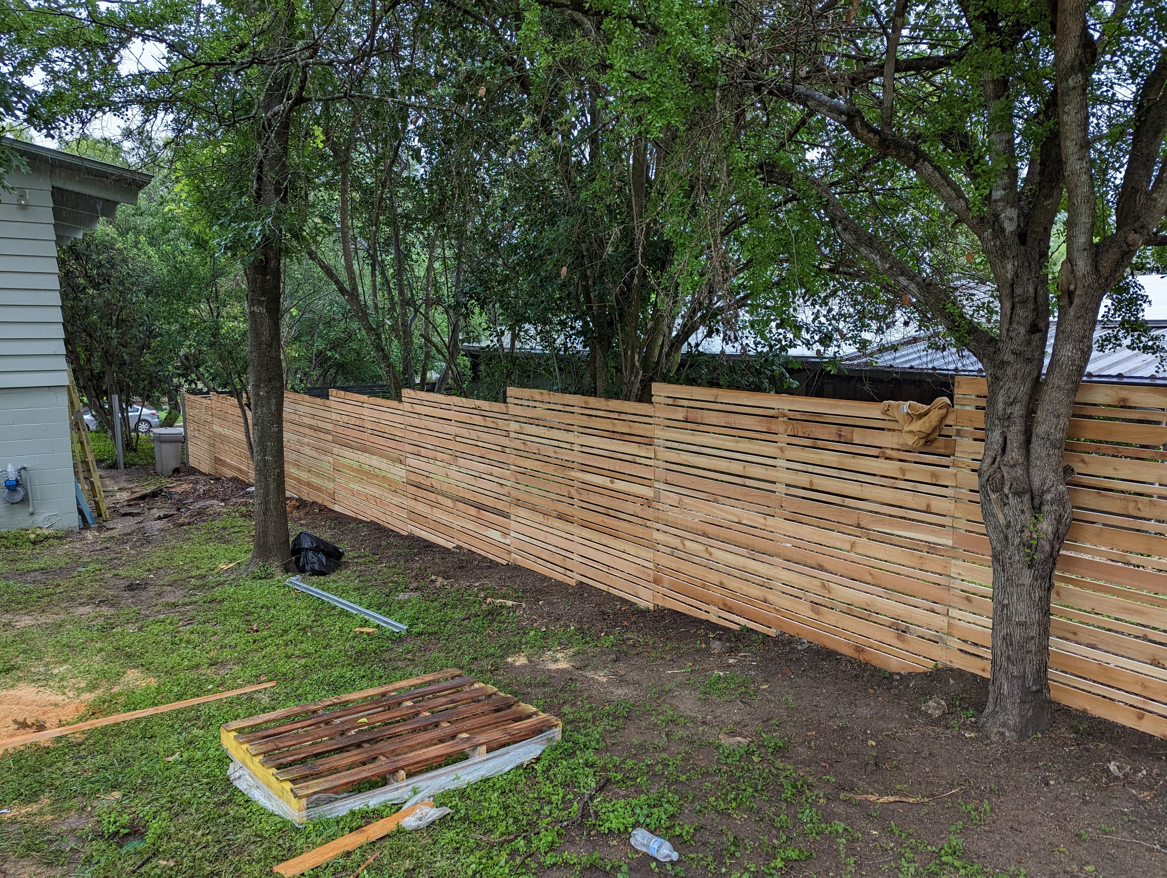 Professional fencing project featuring horizontal cedar fence construction progress