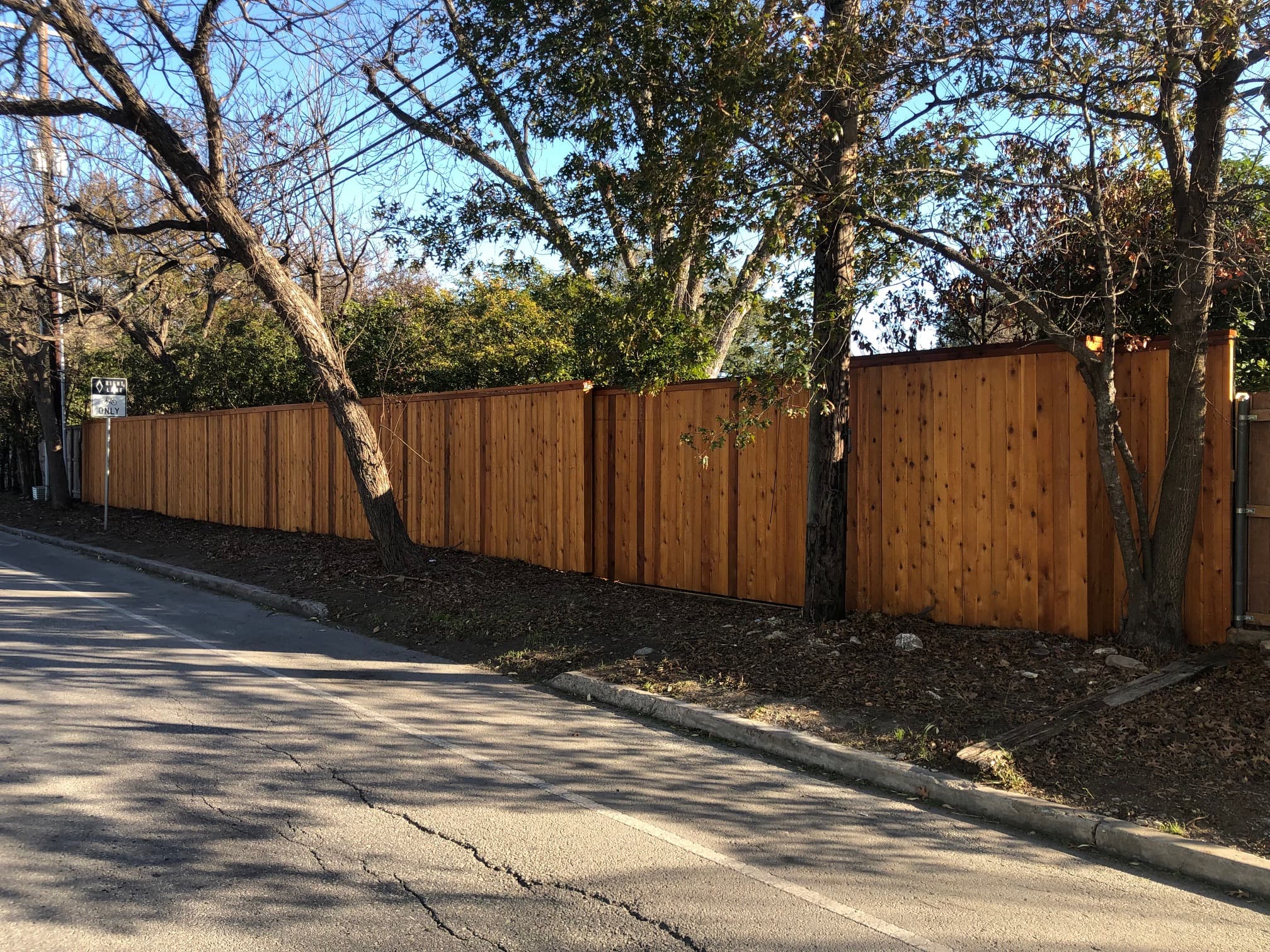 Professional fencing project featuring horizontal cedar fence with gate residential