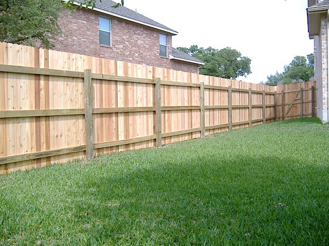 Professional fencing project featuring traditional cedar fence green posts