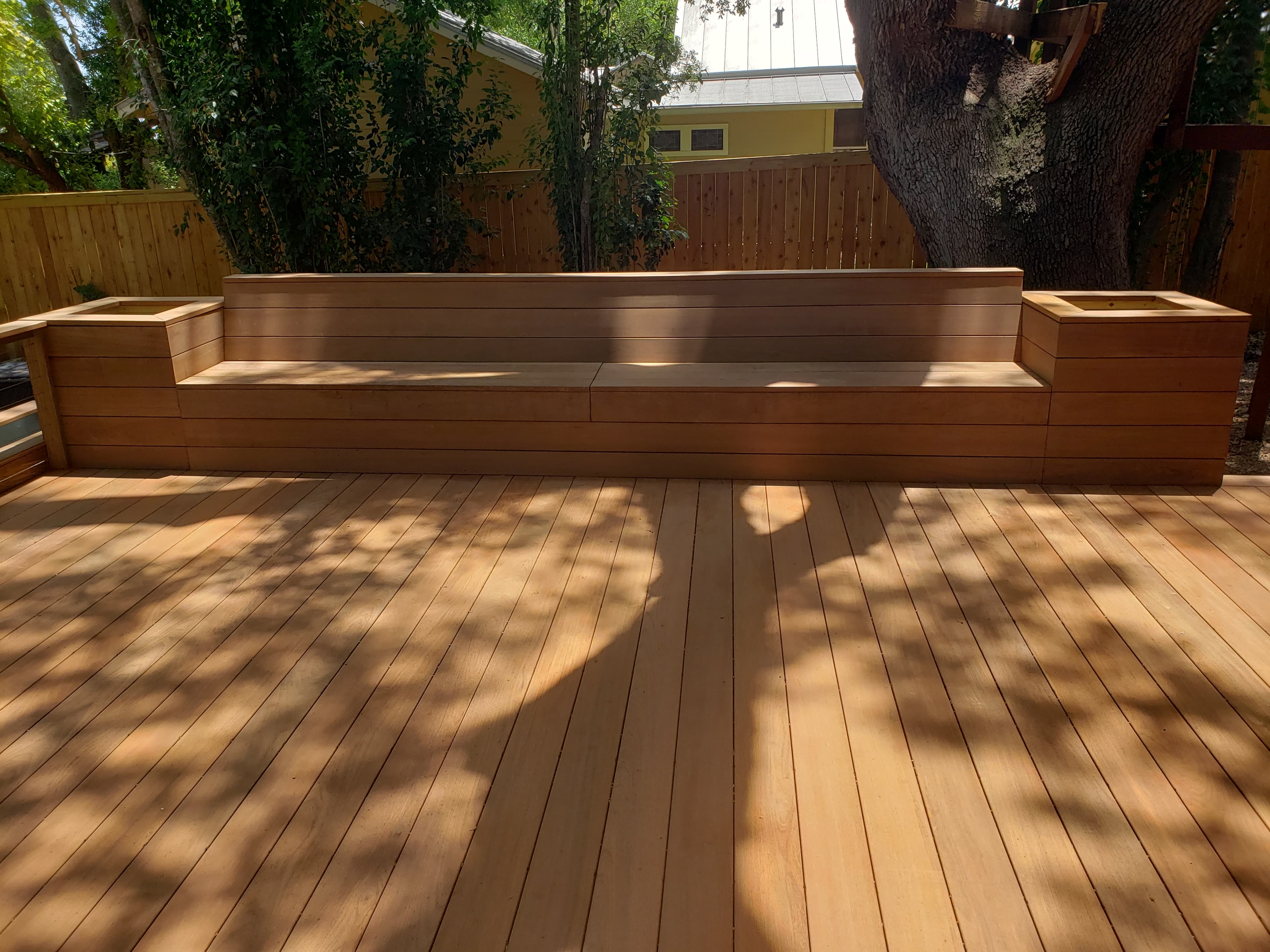 Professional outdoor living project featuring ipe deck built in bench with planters