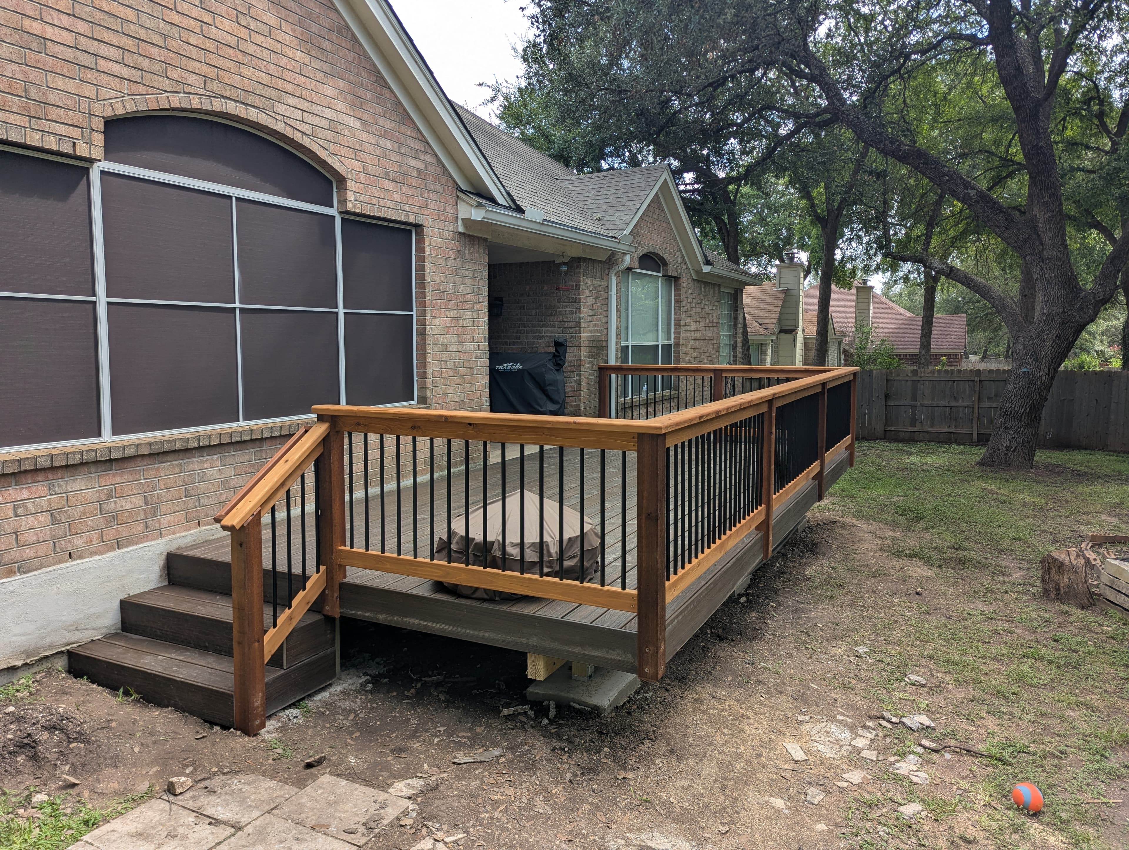 Beautiful cedar deck construction featuring contemporary black metal cable railing system for unobstructed views. The natural cedar decking provides warmth and durability, while the modern railing design adds a sleek, architectural element. This deck seamlessly connects indoor and outdoor living spaces.