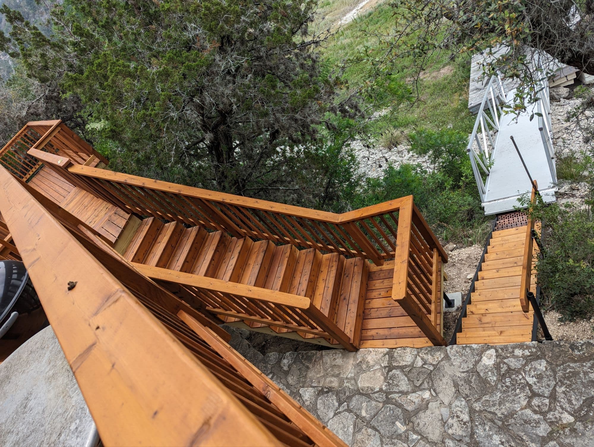 Professional outdoor living project featuring cedar deck stairs hill country hillside