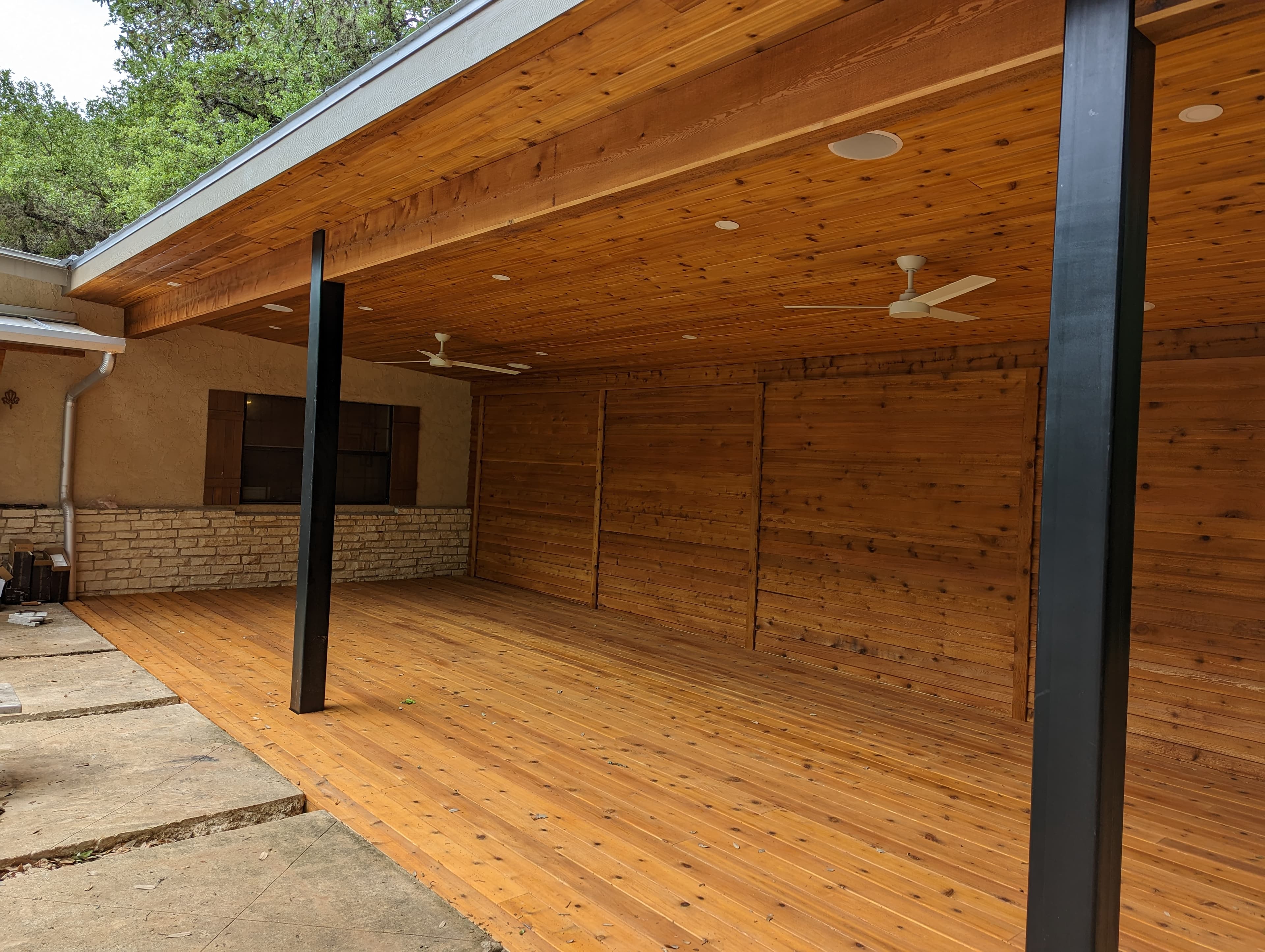 Professional outdoor living project featuring cedar patio cover ceiling fans steel beams