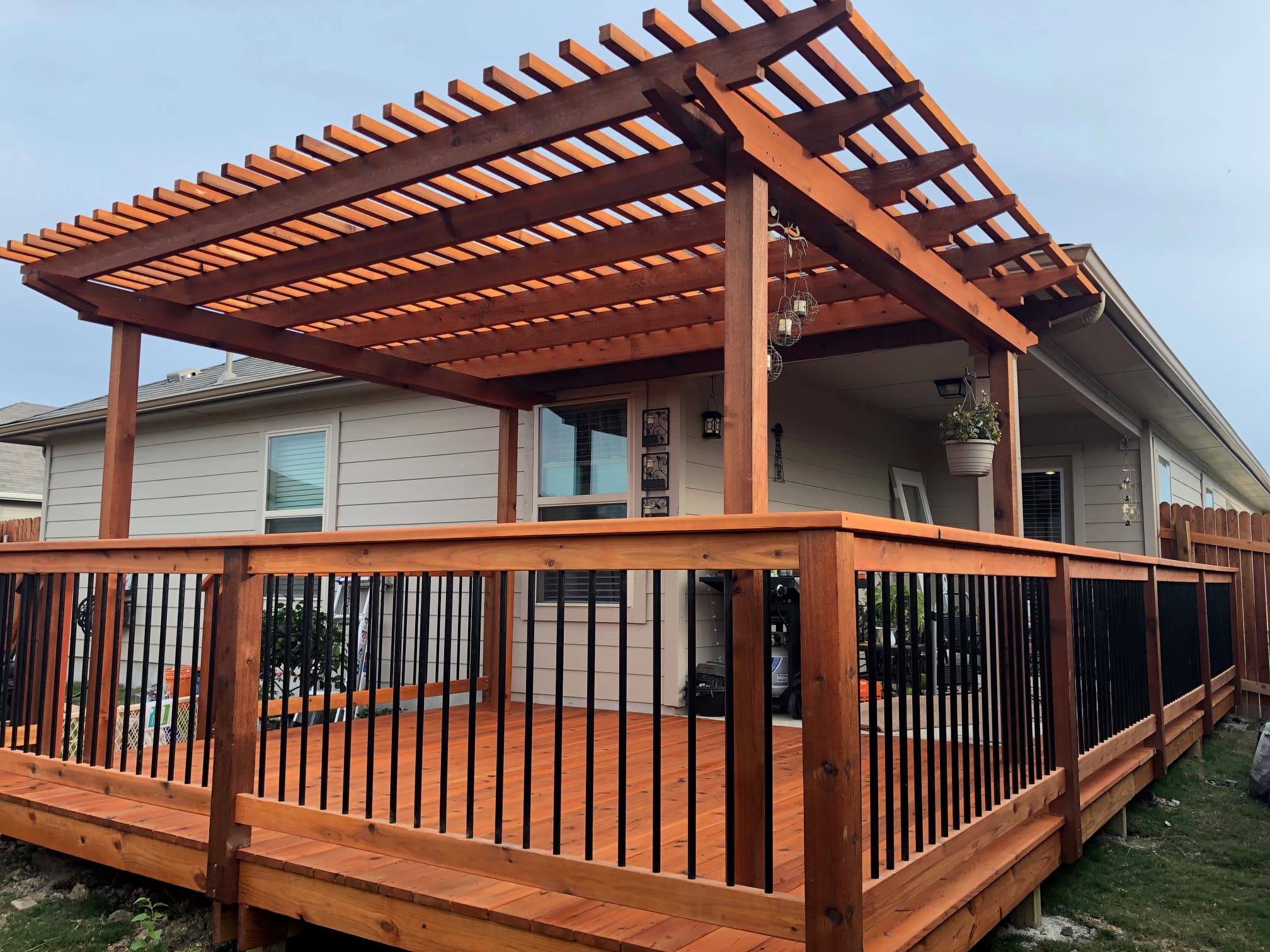Professional outdoor living project featuring cedar pergola with metal railings