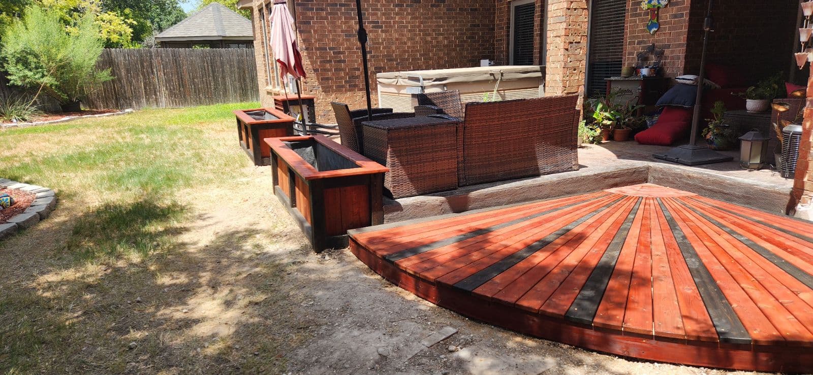 Curved fan-pattern cedar deck platform with two-tone stain and matching planter boxes
