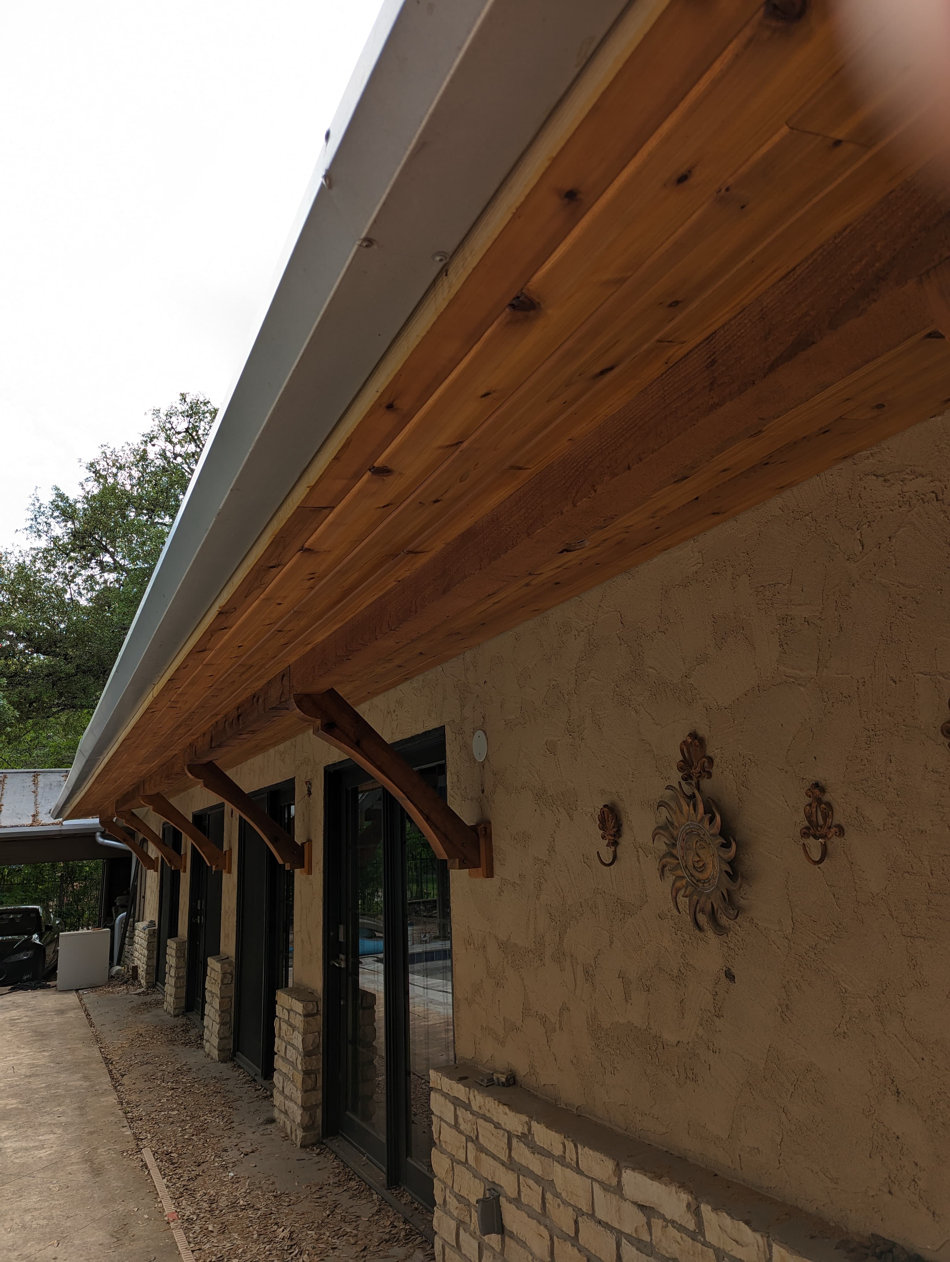Professional outdoor living project featuring patio cover cedar ceiling decorative brackets