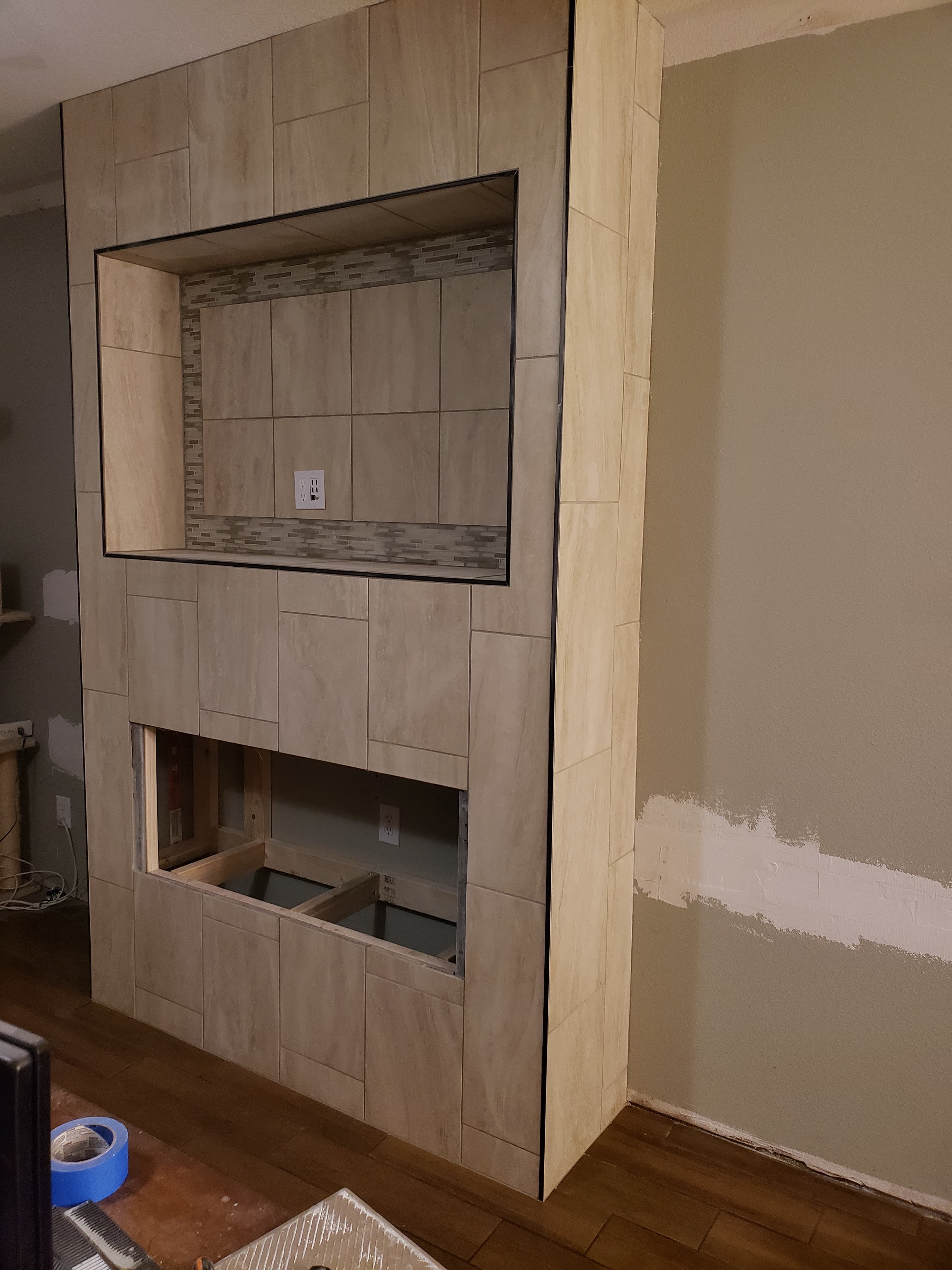 Professional whole home remodel project featuring tile entertainment center with built in fireplace progress