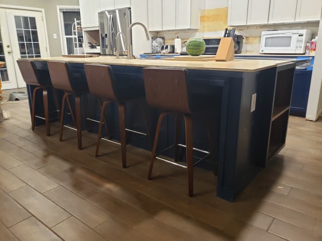Kitchen island with navy cabinets and wood countertop